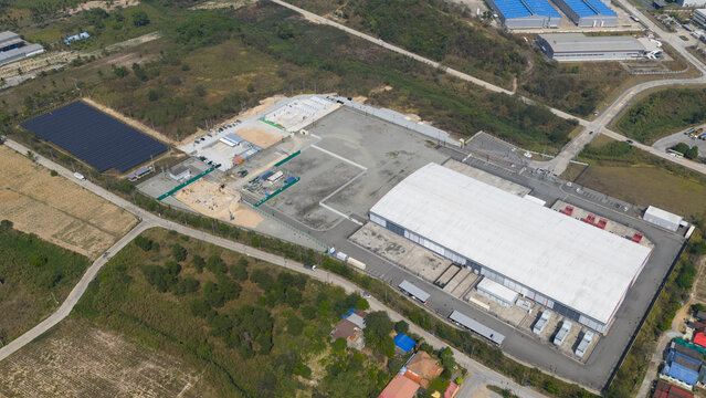 Aerial view of the Data Zone facility featuring a large warehouse, solar panel array, and parking area surrounded by lush greenery in Khao Khansong, Chon Buri, Thailand.