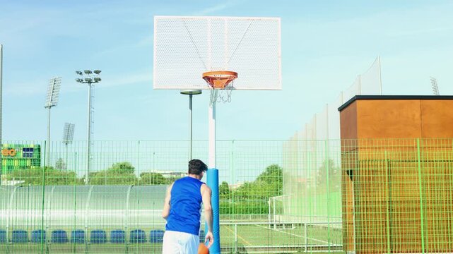 Tattooed basketball player making a perfect shot outdoors