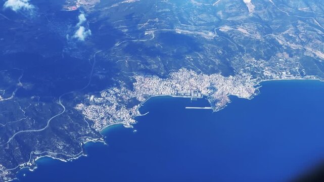Aerial view of a coastal Mediterranean city Kavala in Greece surrounded by mountains and deep blue sea