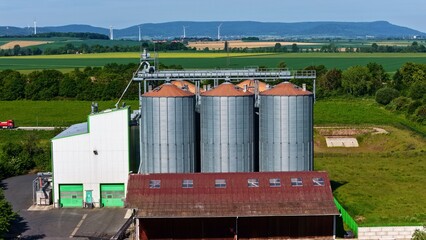 Aerial View of Modern Grain Silos Farm with Wind Turbines in Germany © Maik