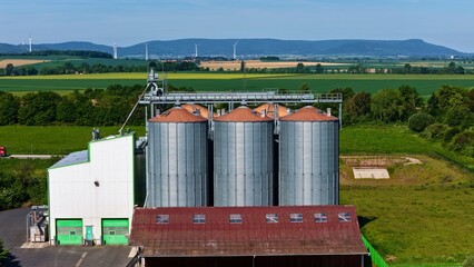 Aerial View of Modern Grain Silos Farm with Wind Turbines in Germany © Maik