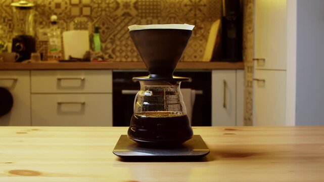 Slow motion coffee dripping from ceramic dripper filter into glass server