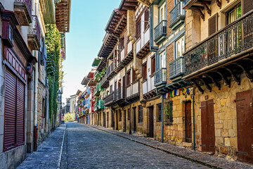 Fototapeta premium Colorful Buildings, Red Shutters, Flower Balconies, Cobblestone Street, Traditional Architecture in Hondarribia, Spain