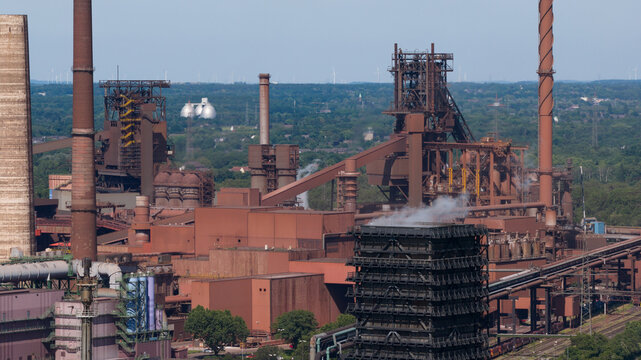 Aerial view of Kokerei Schwelgern KBS thyssenkrupp Steel plant with massive blast furnaces, industrial chimneys, and complex steel structures Duisburg, North Rhine-Westphalia, Germany.