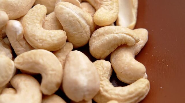 Raw cashew nuts piled inside a bowl. Plant based nutrition ingredient. Rotation