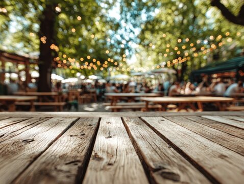 A sun-dappled wooden table in an outdoor beer garden with string lights