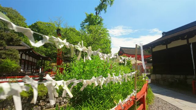 Beatiful garden outside temple in Japan with paper wishes on string, worship