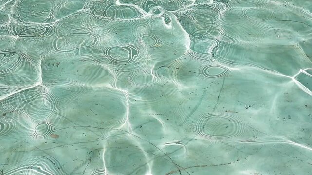 Super slow motion of water reflecting sunlight