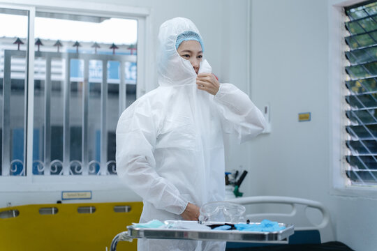 Nurse Pulling Coverall Hood Over Face &ndash; Final Step of Hantavirus PPE Donning