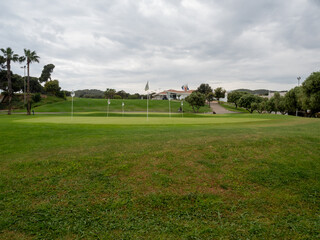Obraz premium Scenic golf course landscape with palm trees and sand path