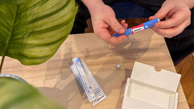 Ozempic injection pen on wooden table with adult hands in warm natural light suitable for medical editorial patient education Ozempic, Semaglutide, GLP-1, 5 May 2026 Serbia Subotica