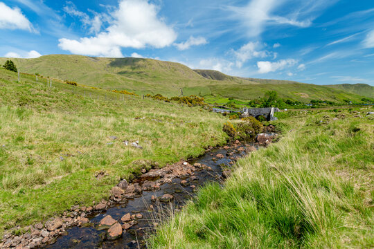 Green mountain valley near Lough Nafooey in Joyce Country, County Galway, Ireland. Rural Irish landscape with stone cottage, fields and hills near the Mayo border.
