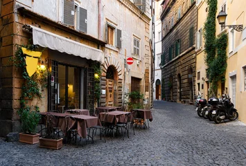 View of old narrow street with tables of restaurant in Rome, Italy. Architecture and landmark of Rome. Cozy cityscape of Rome. © Ekaterina Belova