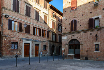 Naklejka premium Medieval small square in Siena, Tuscany, Italy. Architecture and landmark of Siena. Cozy cityscape of Siena