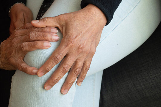 old woman's hand grabbing the hand of a young woman