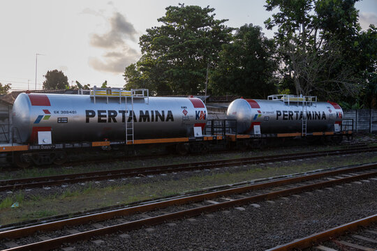 Cilacap, Indonesia - May 13, 2026: Two silver Pertamina fuel tank cars parked on railway tracks at Cilacap station under a late afternoon sky.