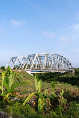 Fototapeta premium The historical Renville railway steel truss bridge under a clear blue sky in Kebumen, Central Java, Indonesia.
