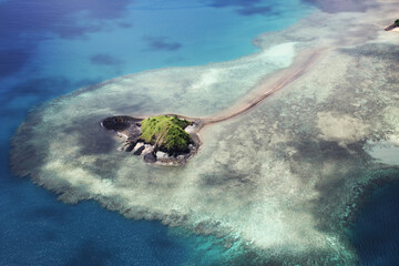 Vue aérienne d'îlot volcanique verdoyant entouré de récif frangeant turquoise à Mayotte © romain