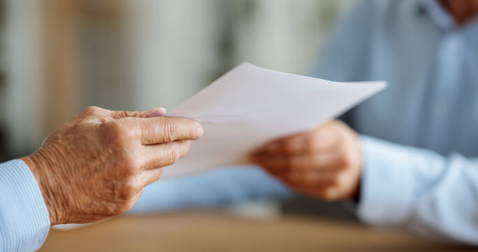 Two people exchanging document paper