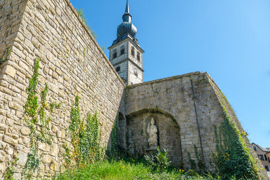 old church (&Eacute;glise Saint-Remi) with tower and statue of saint in village Koerich in Luxembourg