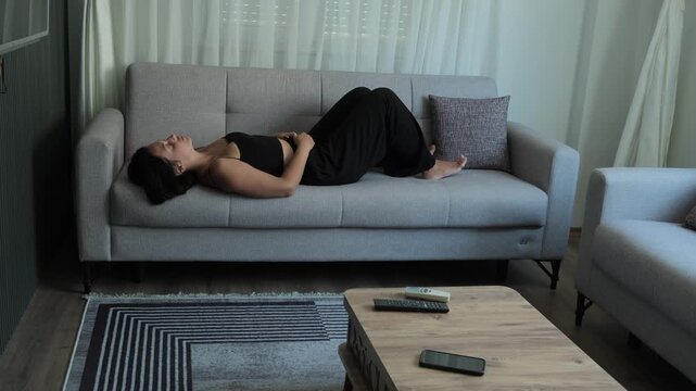 Emotional detachment and dissociation concept with young woman lying on sofa staring at ceiling after prolonged stress, freeze response and emotional numbness