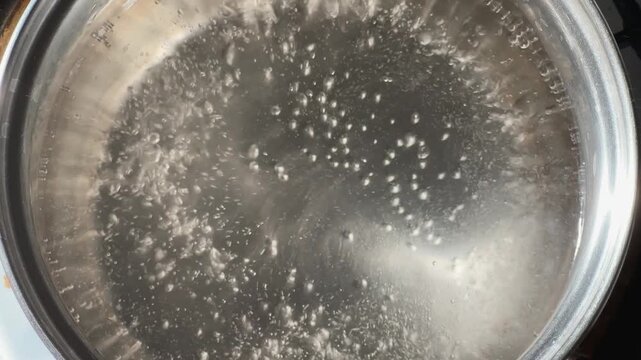 Water in stainless steel pot during the boiling close-up