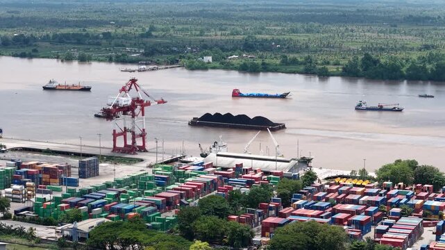 Aerial view of tugboats pulling coal-laden barges near the port