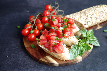 Bruschetta z pomidorami, świeżą bazylią i chrupiącym pieczywem. Traditional Italian appetizer prepared with fresh ingredients. Homemade bruschetta perfect for lunch, party snacks. © Justyna