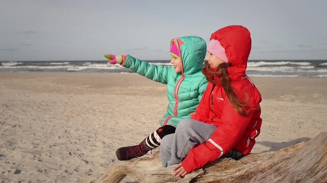 Little beautiful girls sits about sea