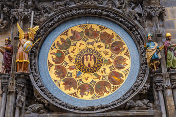 Obraz premium Detailed front view of the historic Orloj calendar dial in Prague, showcasing gold medallions, zodiac signs, and medieval decorative statues.