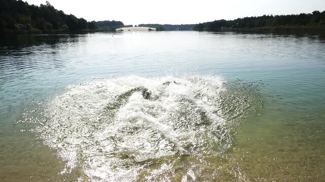 Two sisters dive into a big lake. Summer nature.