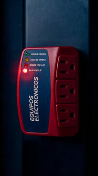 Protector de voltaje para equipos electr&oacute;nicos con luz indicadora de bajo voltaje encendida. Concepto de seguridad el&eacute;ctrica, fallas de energ&iacute;a y protecci&oacute;n de electrodom&eacute;sticos.