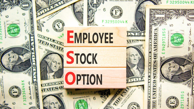 ESO employee stock option symbol. Concept words ESO employee stock option on beautiful wooden blocks. Beautiful dollar bills background. Business ESO employee stock option concept. Copy space.