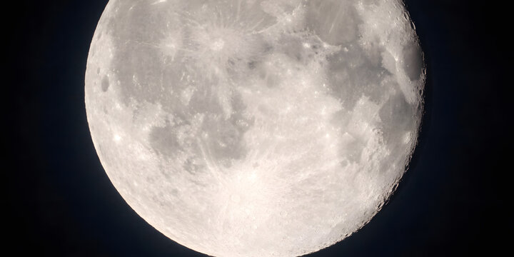 Close up view of the moon in the night sky showing craters and surface details.