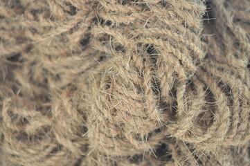 Obraz premium A bunch of tangled brown rope. The rope is knotted and tangled, and it looks like it has been used for a long time. The image has a rustic and worn-out feel to it