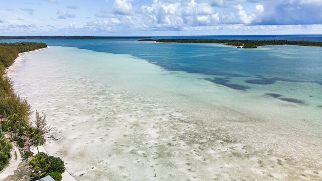 Aerial view of Turtle Beach featuring crystal clear turquoise waters and white sand banks along the lush coastline in Central Eleuthera, The Bahamas.