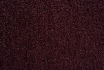 Fototapeta premium Dark burgundy bouclé fabric texture background, maroon textured cloth with grainy pattern.