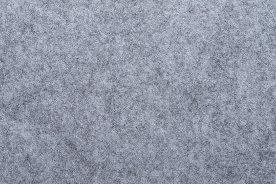 Grey felt fabric texture background, grey wool felt sheet surface with soft fiber pattern.
