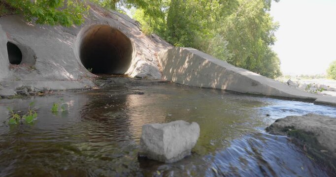 Large round sewage outlet contributing to coastal pollution angle shot