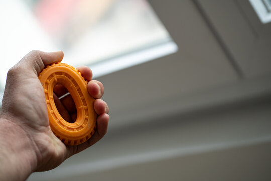 Close-up of a hand holding an orange grip strengthener ring