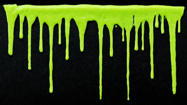 Bright green viscous liquid drips in irregular strands against a dark background