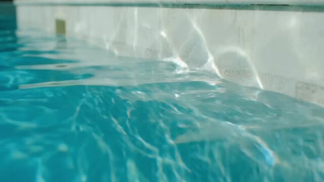Sunlight reflections from swimming pool water, ripple pattern on wall