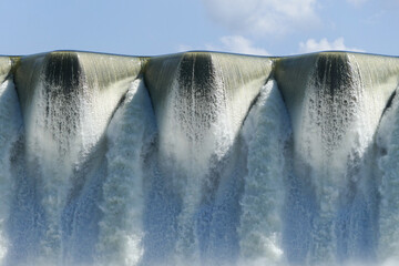 A powerful waterfall cascades under a bright summer sky © Wayne Jones