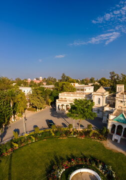 Aerial view of Govt. Central Library featuring historic white architecture with domes, a circular green lawn, and lush trees under a clear blue sky in Bahawalpur, Punjab, Pakistan.