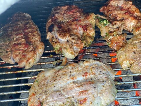 Gegrillte Fleischst&uuml;cke auf einem hei&szlig;en Grillrost mit steak deutlichen Grillstreifen. Authentische BBQ-Szene, Outdoor-Cooking, Sommer, Genuss und rustikale Grillkultur.