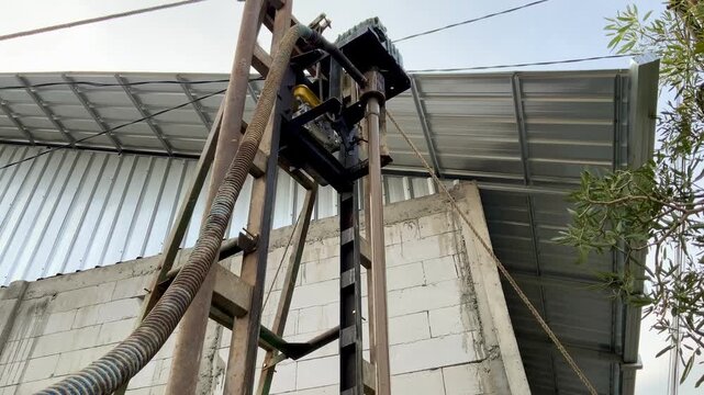 Industrial water well drilling rig machine operating at a construction site