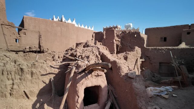 Ushaiqer Heritage Village with traditional Najdi mud-brick houses, narrow alleys and restored adobe walls reflecting ancient desert architecture and cultural history under clear sky of Saudi Arabia