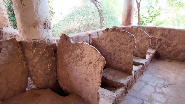 Ushaiqer Heritage Village ablution fountain of ancient mosque in Najdi mud-brick architecture, textured earthen stone-mud walls in warm sunlight, authentic historic detail of Saudi Arabia