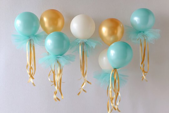 Stylish celebration photo area featuring balloon decorations and a solid white backdrop.
