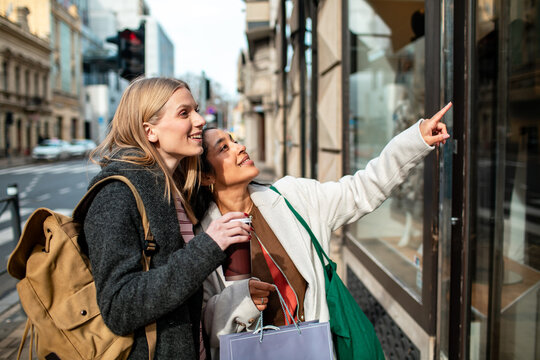 Two friends window shopping on a city street